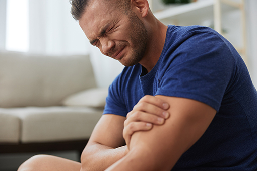 Brandon FL Man Holding Hurt Arm In Need of Personal Injury Chiropractor