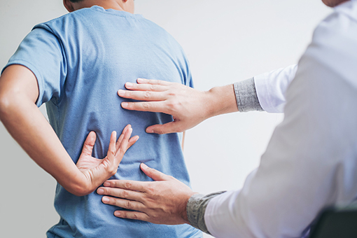 Brandon Florida Man Pointing What Part of Back Hurts to Chiropractor Specializing in Disc Injuries