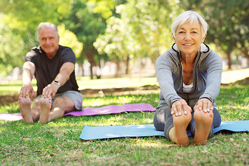 Senior Couple with Disc Injuries Doing Stretching Exercises in a Park in Brandon FL After Visiting Chiropractor