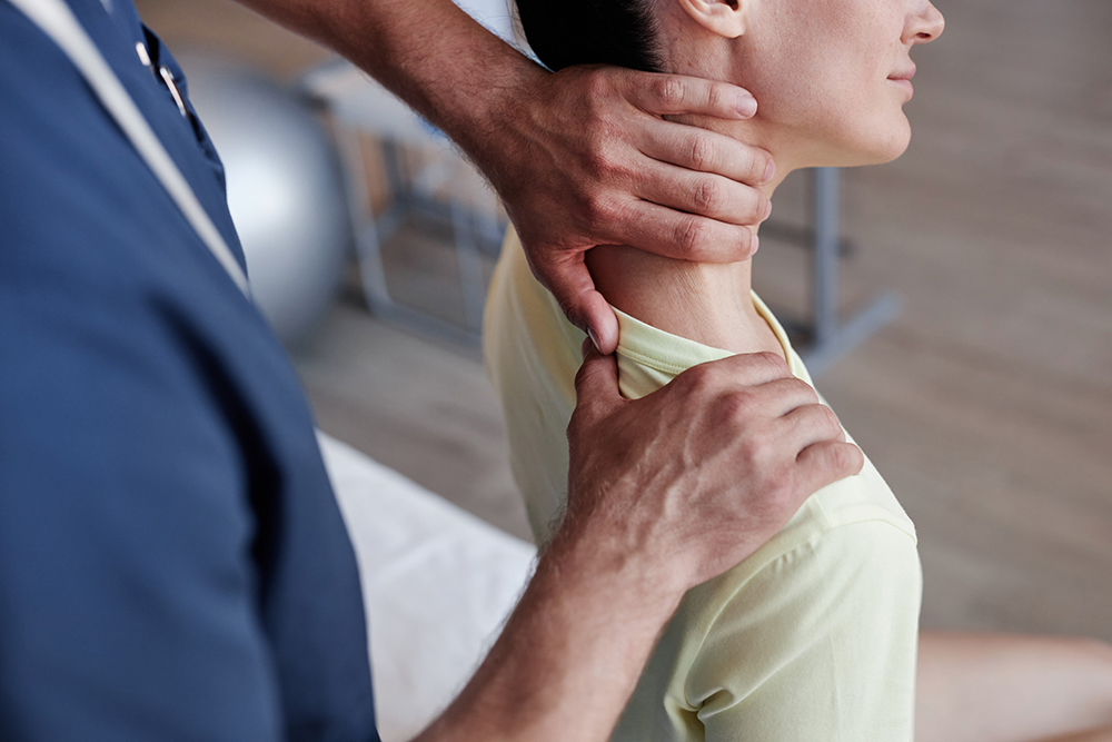Chiropractor Checking Neck and Shoulder of Brandon FL Receiving Therapy for Whiplash Injury