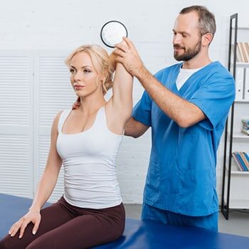 Riverview Chiropractor Guiding a Brandon Lady on Physiotherapy Exercises